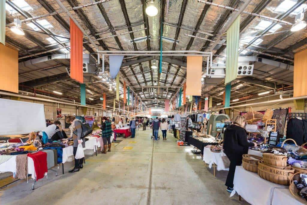 "Vibrant scene at Canberra's famous Old Bus Depot Market, bustling with local produce and crafts."